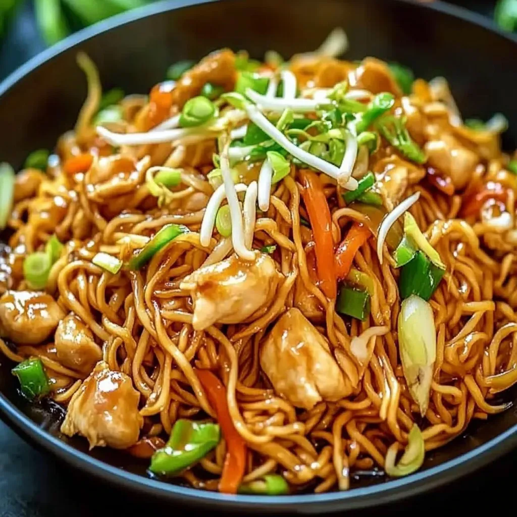 Ein Wok-Nudel-Gericht mit Hähnchen und Sojasprossen.